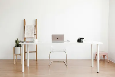 A laptop on a desk in a bright, minimal office
